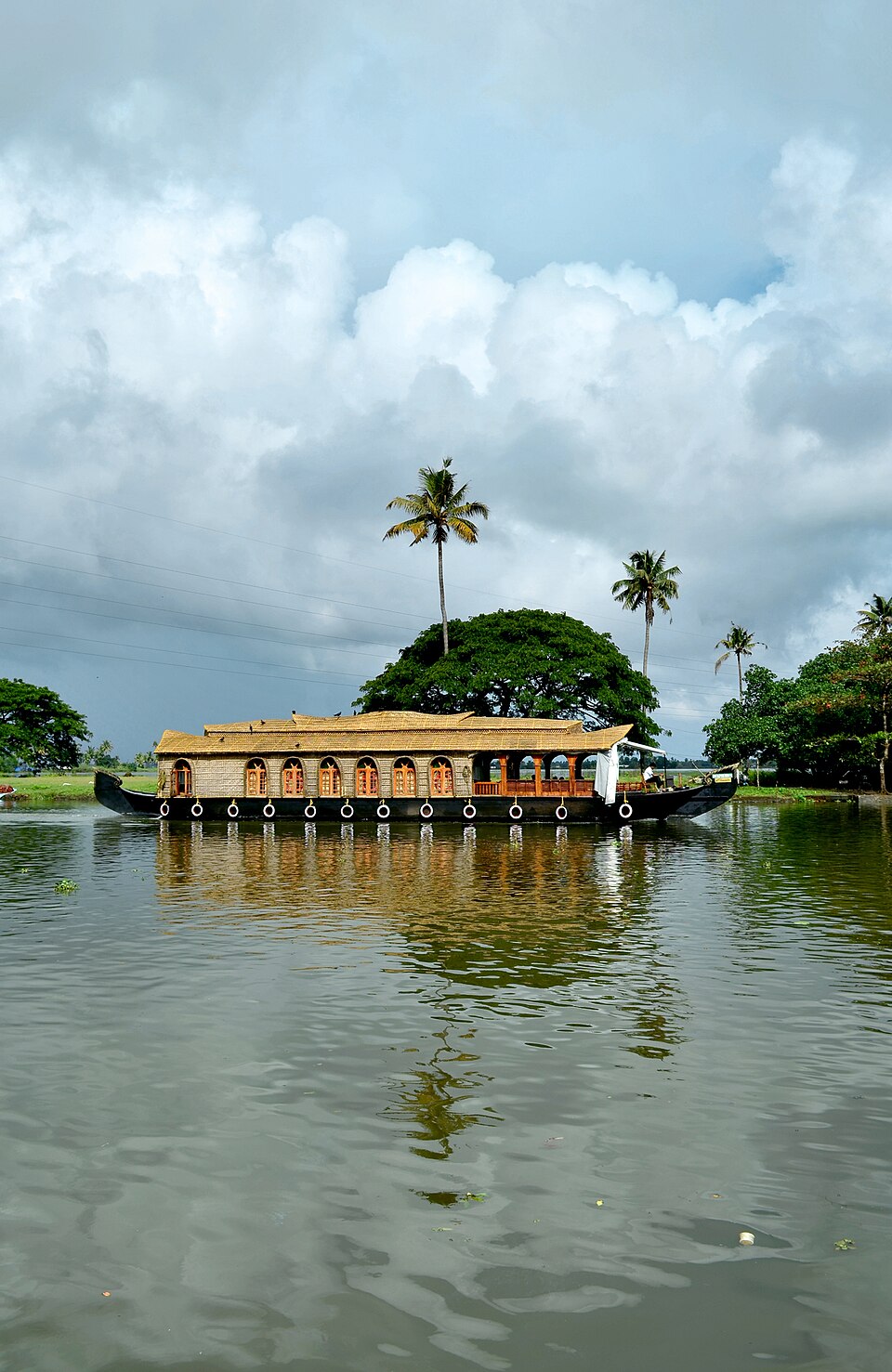 A traditional houseboat drifting through Kerala's backwaters at dusk